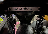 Close-up of a vehicle suspension system with 'COME FROM' written on it.